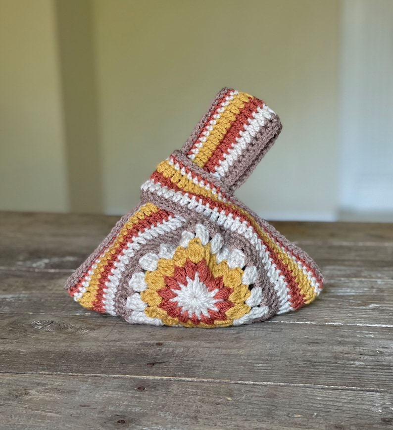 Crochet sunburst knot bag pattern. This beautiful motif crochet pattern is versatile and functional. This boho crochet bag pattern features a crochet flower sunburst design that makes this boho handbag really stand out.