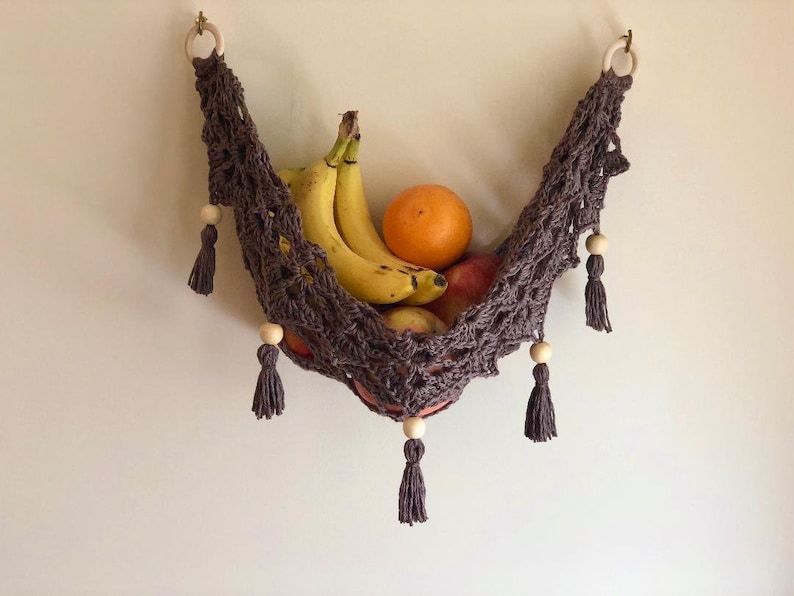 Crochet hammock pattern works as a crochet wall hanging, crochet fruit holder, or crochet home decor organizer. The lacy crochet stitch design makes this pattern both fashionable and functional.