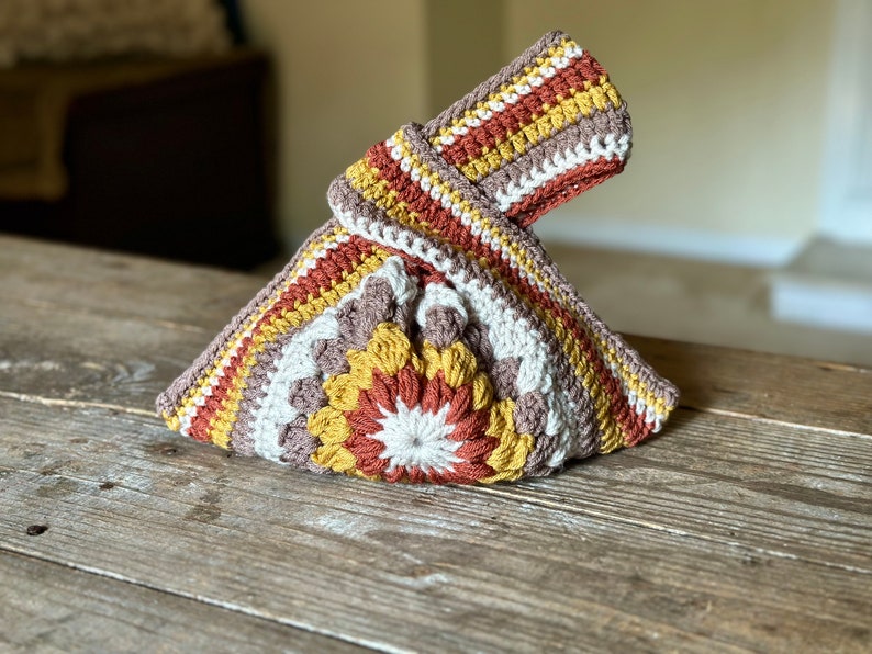 Crochet sunburst knot bag pattern. This beautiful motif crochet pattern is versatile and functional. This boho crochet bag pattern features a crochet flower sunburst design that makes this boho handbag really stand out.