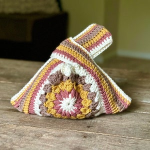 Crochet sunburst knot bag pattern. This beautiful motif crochet pattern is versatile and functional. This boho crochet bag pattern features a crochet flower sunburst design that makes this boho handbag really stand out.