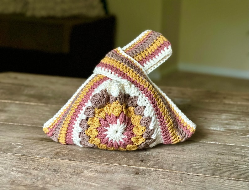 Crochet sunburst knot bag pattern. This beautiful motif crochet pattern is versatile and functional. This boho crochet bag pattern features a crochet flower sunburst design that makes this boho handbag really stand out.