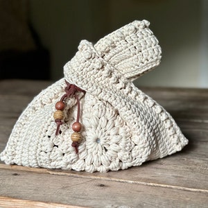 Crochet sunburst knot bag pattern. This beautiful motif crochet pattern is versatile and functional. This boho crochet bag pattern features a crochet flower sunburst design that makes this boho handbag really stand out.