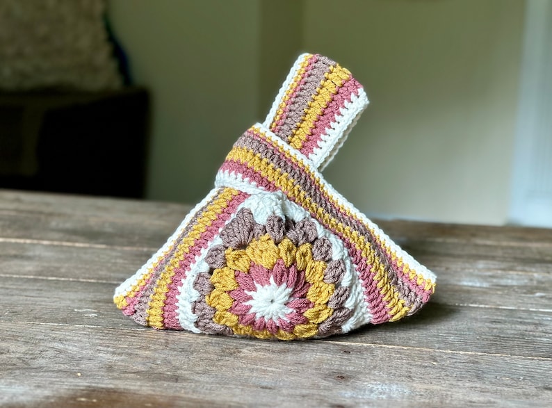 Crochet sunburst knot bag pattern. This beautiful motif crochet pattern is versatile and functional. This boho crochet bag pattern features a crochet flower sunburst design that makes this boho handbag really stand out.