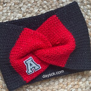 May include: Black and red knit headband with a sparkly finish. The headband has a large red bow and a white felt letter "A" with rhinestones on it. The text "daysck.com" is printed on the headband.