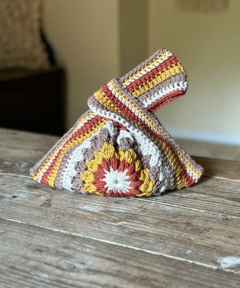Crochet sunburst knot bag pattern. This beautiful motif crochet pattern is versatile and functional. This boho crochet bag pattern features a crochet flower sunburst design that makes this boho handbag really stand out.