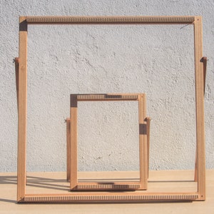 Può includere: Due telai in legno per la tessitura, uno annidato nell'altro. Il telaio più grande è alto circa 30 cm e largo 40 cm. Il telaio più piccolo è alto circa 20 cm e largo 25 cm.