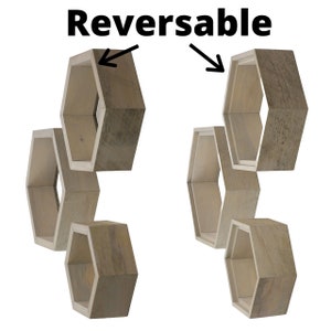 May include: Set of five reversible wooden hexagon shelves. The shelves are light brown and have a natural wood grain finish. The shelves can be mounted on a wall or used as free-standing shelves.