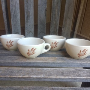 May include: Set of four white ceramic coffee mugs with brown wheat design.