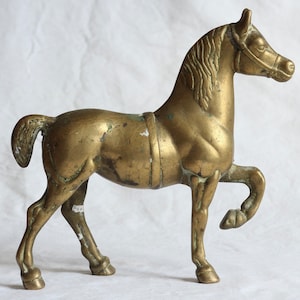 Vintage brass horse statue. Cast metal. Aged. Patinated. Midcentury. Equestrian ornament. Gold tone. Verdigris. Circa 1960s.