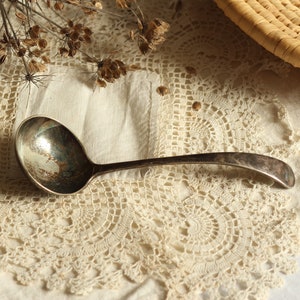Vintage silver-plated sauce ladle. Small sized. Long-handled. Patinated. Aged. Curved shape. Serving spoon. Circa early 20th century.