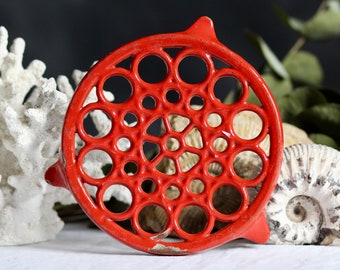 Vintage verouderde metalen onderzetter. Rood email. Kandelaar. Met poten. Kerstmis. Feestelijk. Chippy decor. Circa midden - eind 20e eeuw.