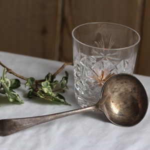 Vintage silver-plated serving ladle. Hallmarked silver. Long-handled. Curved shape. Soup spoon. Circa early 20th century.