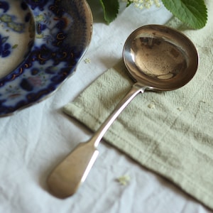 Vintage silver-plated serving ladle. Hallmarked silver. Long-handled. Curved shape. Soup spoon. Circa early 20th century.