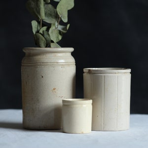 Collection of three antique storage pots. Earthenware. Pale ceramic. Food storage jars. Zero waste. Eco kitchen. Circa early 20th century.