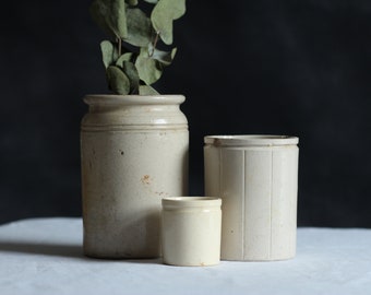 Collection of three antique storage pots. Earthenware. Pale ceramic. Food storage jars. Zero waste. Eco kitchen. Circa early 20th century.