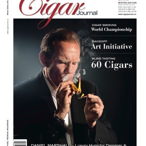 May include: A man in a black suit and white shirt is holding a lit cigar. The magazine cover features the text "Cigar Journal", "World Championship", "Davidoff Art Initiative", "Blind Tasting 60 Cigars", and "Daniel Marshall - Luxury Humidor Designer & ... MR. GOLDEN CIGAR".