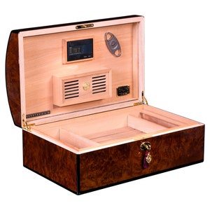 May include: A brown wooden humidor with a cedar interior. The humidor has a digital hygrometer, a built-in humidifier, and a cedar divider. The humidor is open and the lid is propped up.
