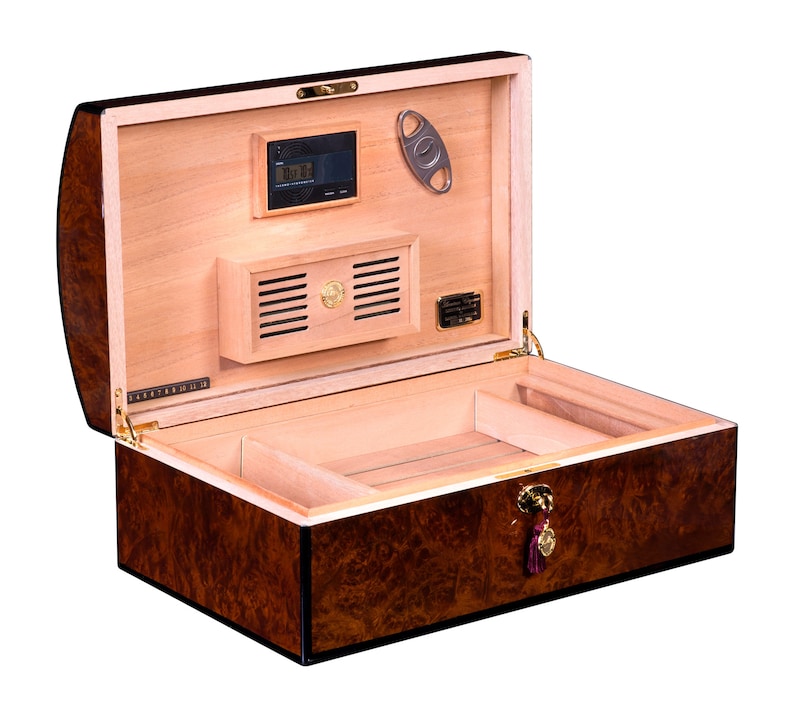 May include: A brown wooden humidor with a cedar interior. The humidor has a digital hygrometer, a built-in humidifier, and a cedar divider. The humidor is open and the lid is propped up.