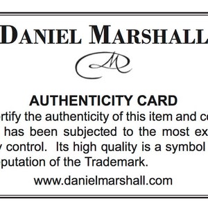 May include: A black and white authenticity card with the text "DANIEL MARSHALL" and "AUTHENTICITY CARD". The card also includes the text "We certify the authenticity of this item and confirm that it has been subjected to the most exacting quality control. Its high quality is a symbol of the fine reputation of the Trademark." and "www.danielmarshall.com".