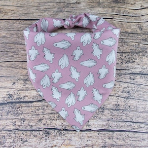 May include: A pink bandana with a white ghost pattern. The bandana is tied in a knot at the top.