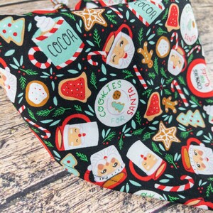 May include: Black bandana with a Christmas-themed print featuring Santa mugs, cookies, candy canes, and the text "Cookies for Santa".