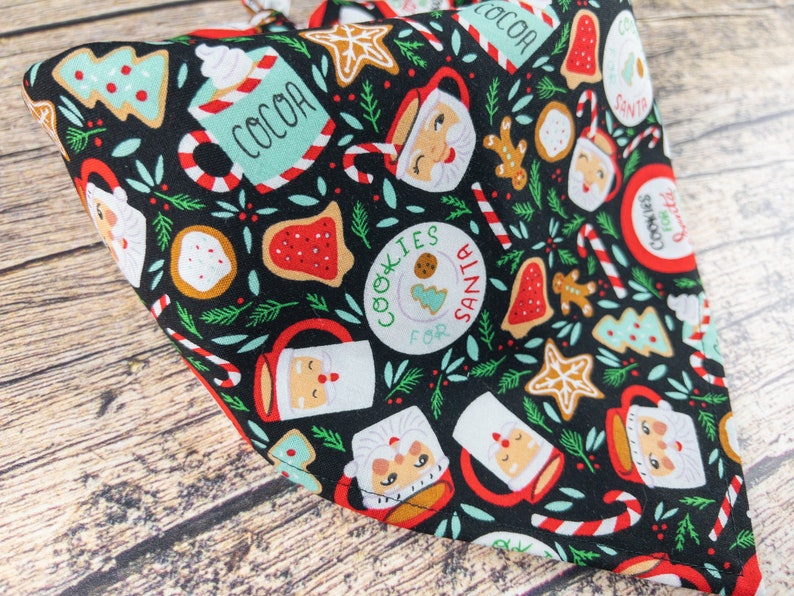 May include: Black bandana with a Christmas-themed print featuring Santa mugs, cookies, candy canes, and the text "Cookies for Santa".