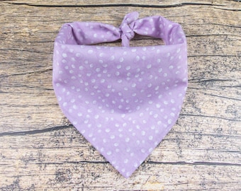 May include: A lavender bandana with a white polka dot pattern. The bandana is tied in a knot at the top.