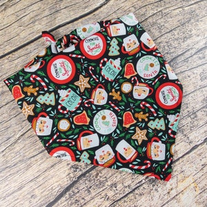 May include: A black bandana with a Christmas-themed print featuring cookies, candy canes, cocoa mugs, and the text "Cookies for Santa".