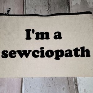 Puede incluir: Una bolsa de lona blanca con cremallera y texto negro que dice "I'm a sewciopath".