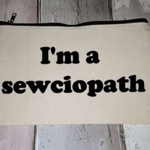 Puede incluir: Una bolsa de lona blanca con cremallera y texto negro que dice "I'm a sewciopath".