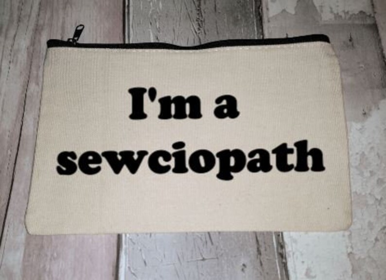 Puede incluir: Una bolsa de lona blanca con cremallera y texto negro que dice "I'm a sewciopath".
