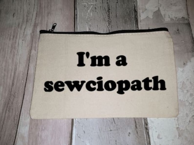 Puede incluir: Una bolsa de lona blanca con cremallera y texto negro que dice "I'm a sewciopath".