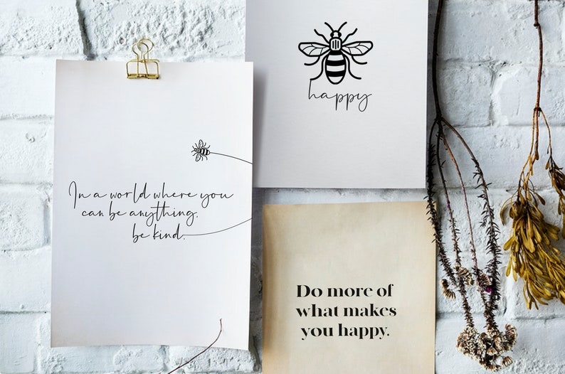 May include: Three inspirational quotes printed on white paper with black ink. The first quote reads "In a world where you can be anything, be kind." The second quote reads "happy" with a bee illustration. The third quote reads "Do more of what makes you happy."