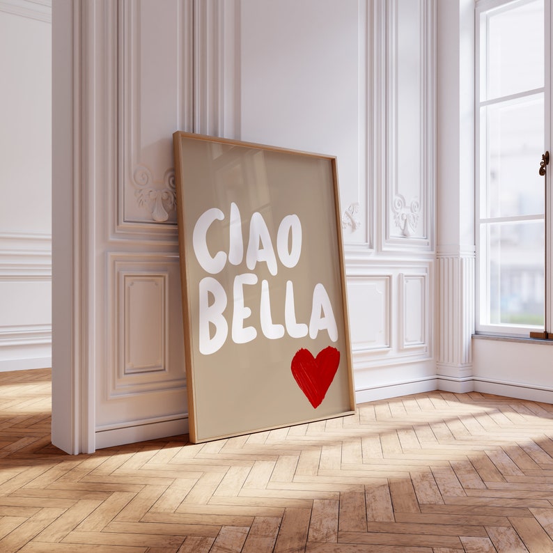 May include: A framed print with a brown background and white text that says "Ciao Bella" with a red heart underneath.