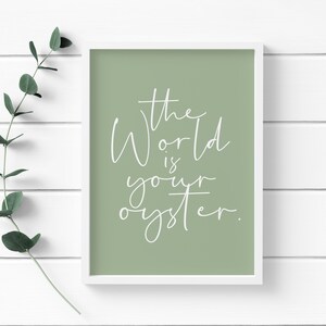 May include: A sage green framed print with white text that reads "The World is your oyster."