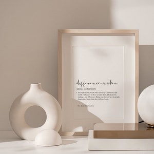 May include: A framed print with the word "difference maker" defined as "An inspirational person who encourages, motivates and instills confidence in those around them. Dedicated to making a real difference. Brings out the very best in people. Appreciated more than they will ever know."