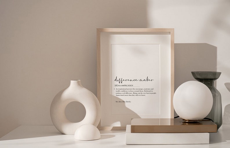 May include: A framed print with the word "difference maker" defined as "An inspirational person who encourages, motivates and instills confidence in those around them. Dedicated to making a real difference. Brings out the very best in people. Appreciated more than they will ever know."
