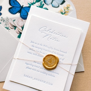 May include: Wedding invitation suite. A white card with embossed text is sealed with gold wax and tied with gold string. The envelope features butterfly and floral designs. The text reads 'Celebration Notice' and 'SARAH_ANDREW.COM'.