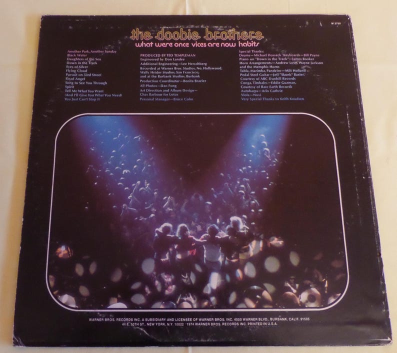 Puede incluir: La contraportada de un disco de vinilo de The Doobie Brothers. El t&iacute;tulo del &aacute;lbum es "What Were Once Vices Are Now Habits". La portada del &aacute;lbum presenta una fotograf&iacute;a en blanco y negro de una multitud de personas en un concierto. Las luces del escenario brillan intensamente sobre la multitud.