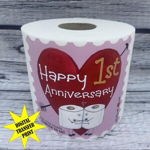 May include: A pink and white toilet paper roll with a red heart and gold lettering that says "Happy 1st Anniversary".  The heart has an arrow through it and two toilet paper rolls with faces are hugging.  The text below the heart says "One year down...forever to go!"