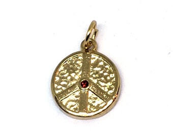 Puede incluir: Encanto de signo de paz dorado con una piedra preciosa roja en el centro. El encanto tiene una superficie texturizada.