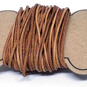 May include: A spool of brown leather cord, wound tightly and ready for crafting projects.