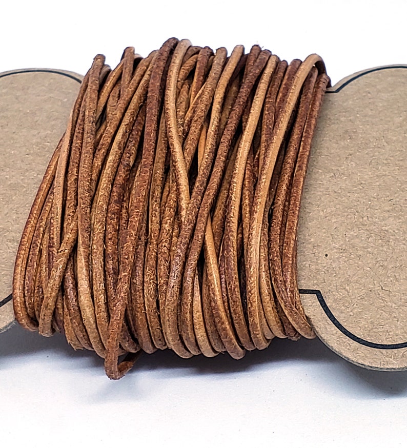 May include: A spool of brown leather cord, wound tightly and ready for crafting projects.