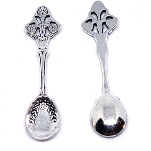 Peut inclure: Deux cuill&egrave;res &agrave; caf&eacute; en argent avec des manches orn&eacute;s et un motif floral. Les cuill&egrave;res ont un bol arrondi et sont parfaites pour servir de petites portions.