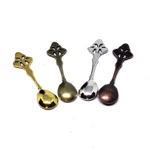 Peut inclure: Quatre cuill&egrave;res d&eacute;coratives orn&eacute;es aux finitions dor&eacute;e, argent&eacute;e, bronze et cuivre. Chaque cuill&egrave;re pr&eacute;sente un motif floral d&eacute;licat sur le manche et un bol arrondi.