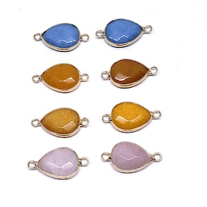 May include: Eight teardrop-shaped gemstone connectors with gold-toned metal loops. The gemstones are in four colors: light blue, yellow, orange, and pink.
