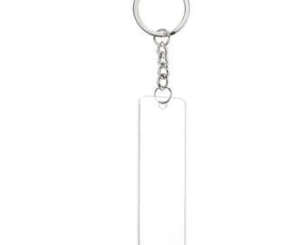 May include: A clear acrylic keychain with a silver metal chain and ring. The keychain is rectangular and has a smooth surface.