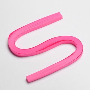 May include: A pink paper quilling strip, a long, thin strip of paper used for creating intricate paper crafts.