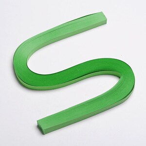May include: A green paper quilling strip, a type of paper craft, is curled into an S shape.