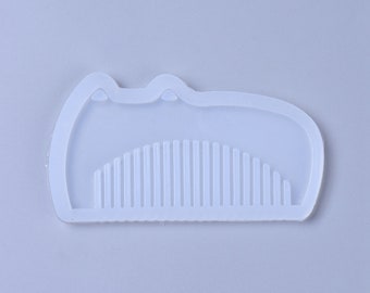 May include: A white silicone mold shaped like a comb. The mold is designed to create resin crafts.